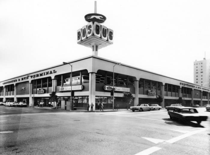 black and white photo of the northwest corner of the building. a greyhound coach can be seen through the arches on the second floor. the rooftop sign has a greyhound logo on the upper oval, and the word BUS spelled out on the rectangles