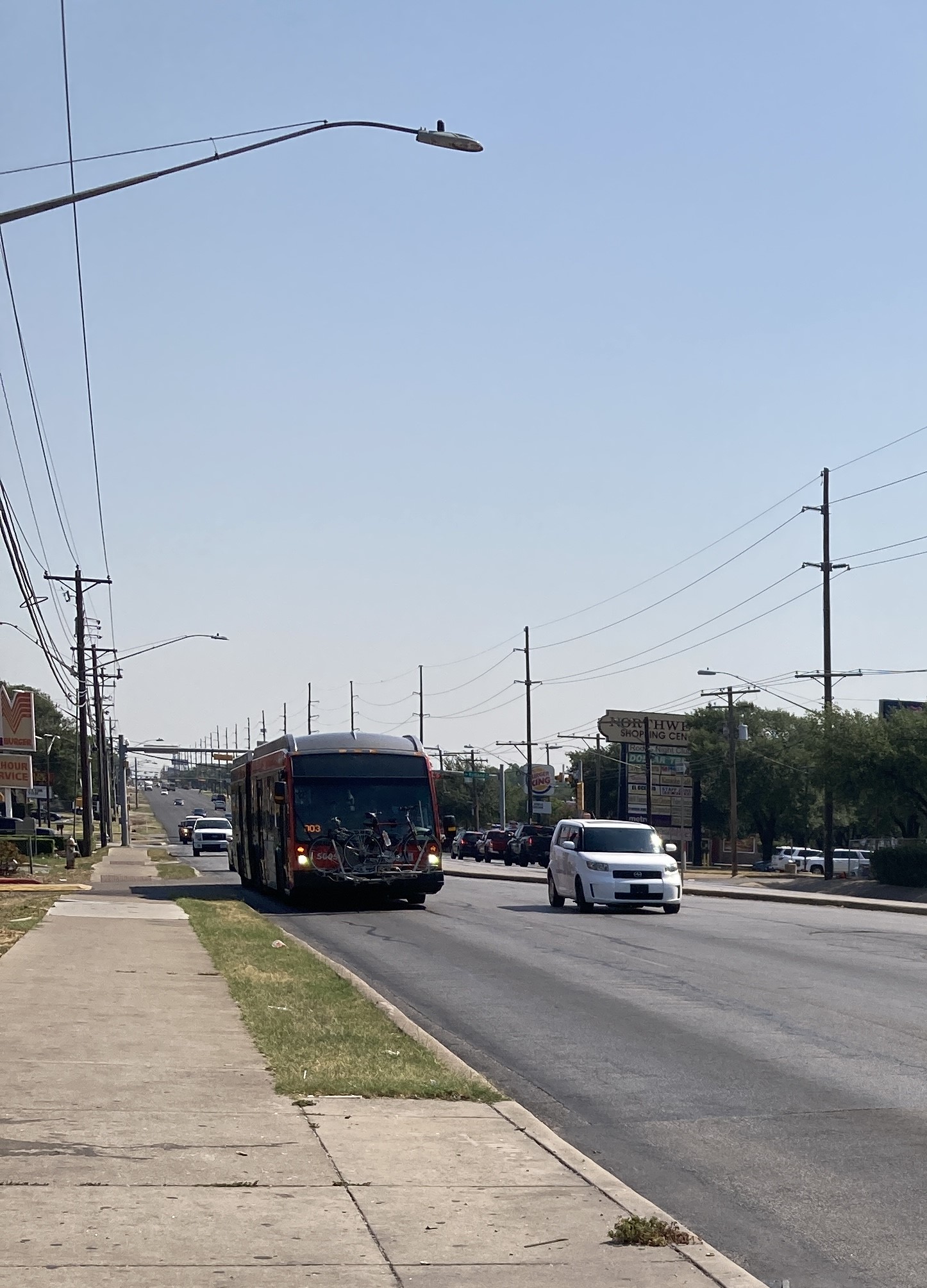 an articulated bus with round sealed beam headlights approaches on lamar avenue.