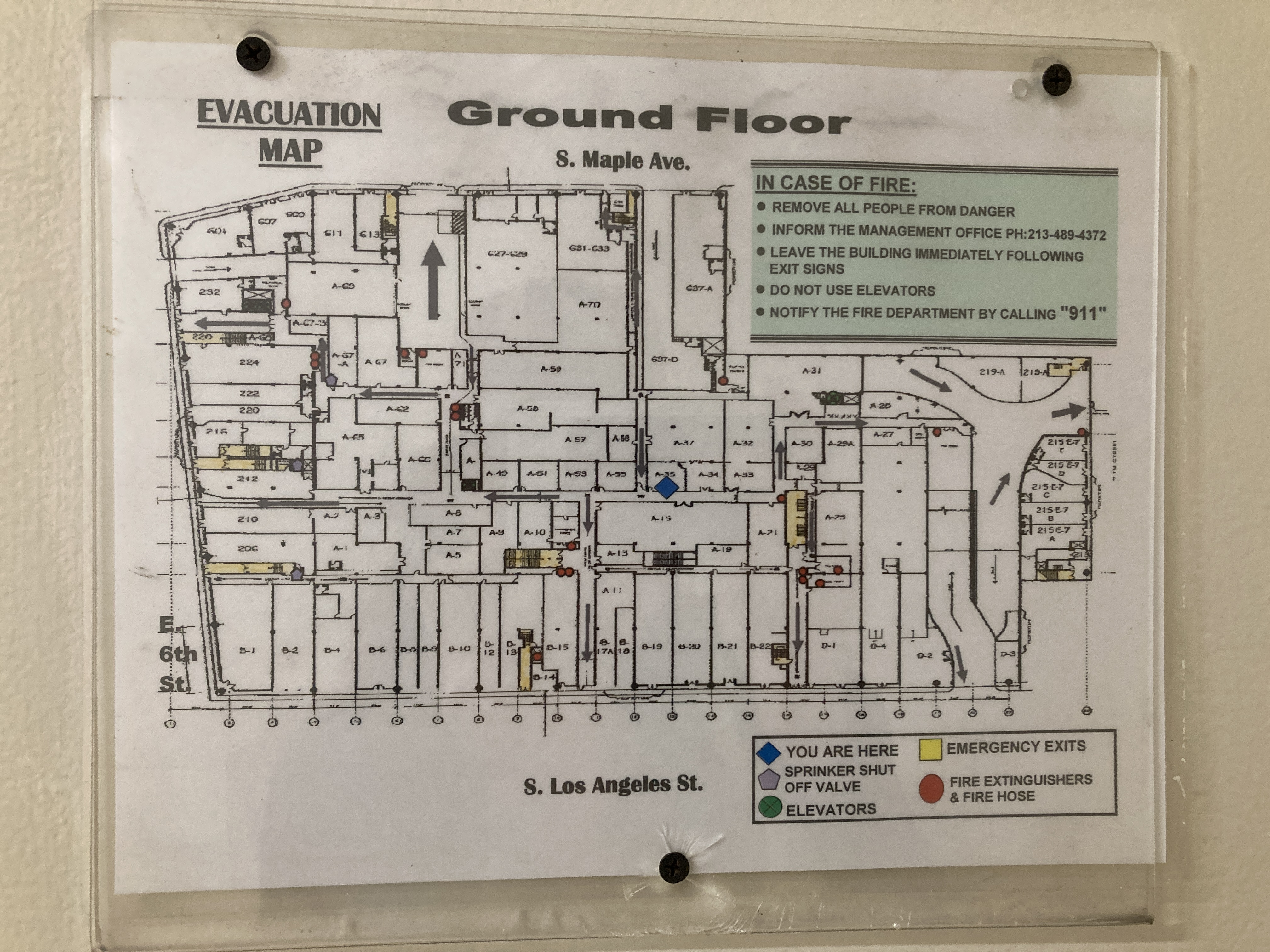 an interior hallway. printed fire evacuation map of the building. There are so many hallways and rooms, i'm not even sure how to describe the map