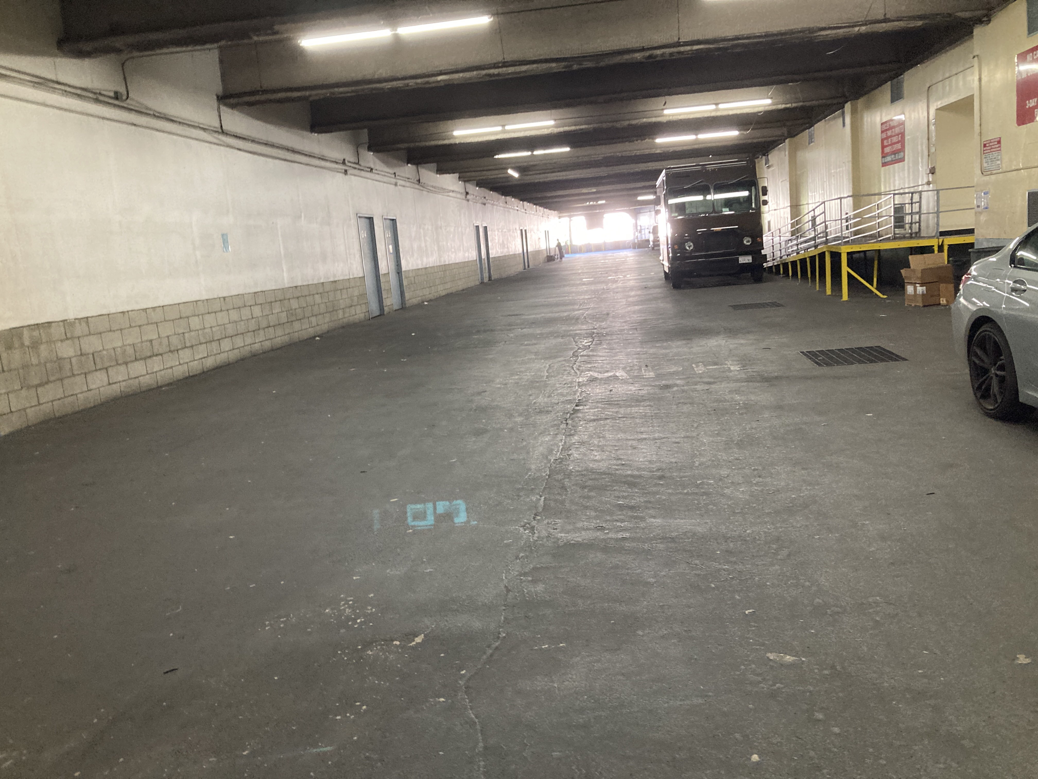 Looking along the upper floor vehicle hallway. A step van is parked next to a ramp leading up to a loading dock.